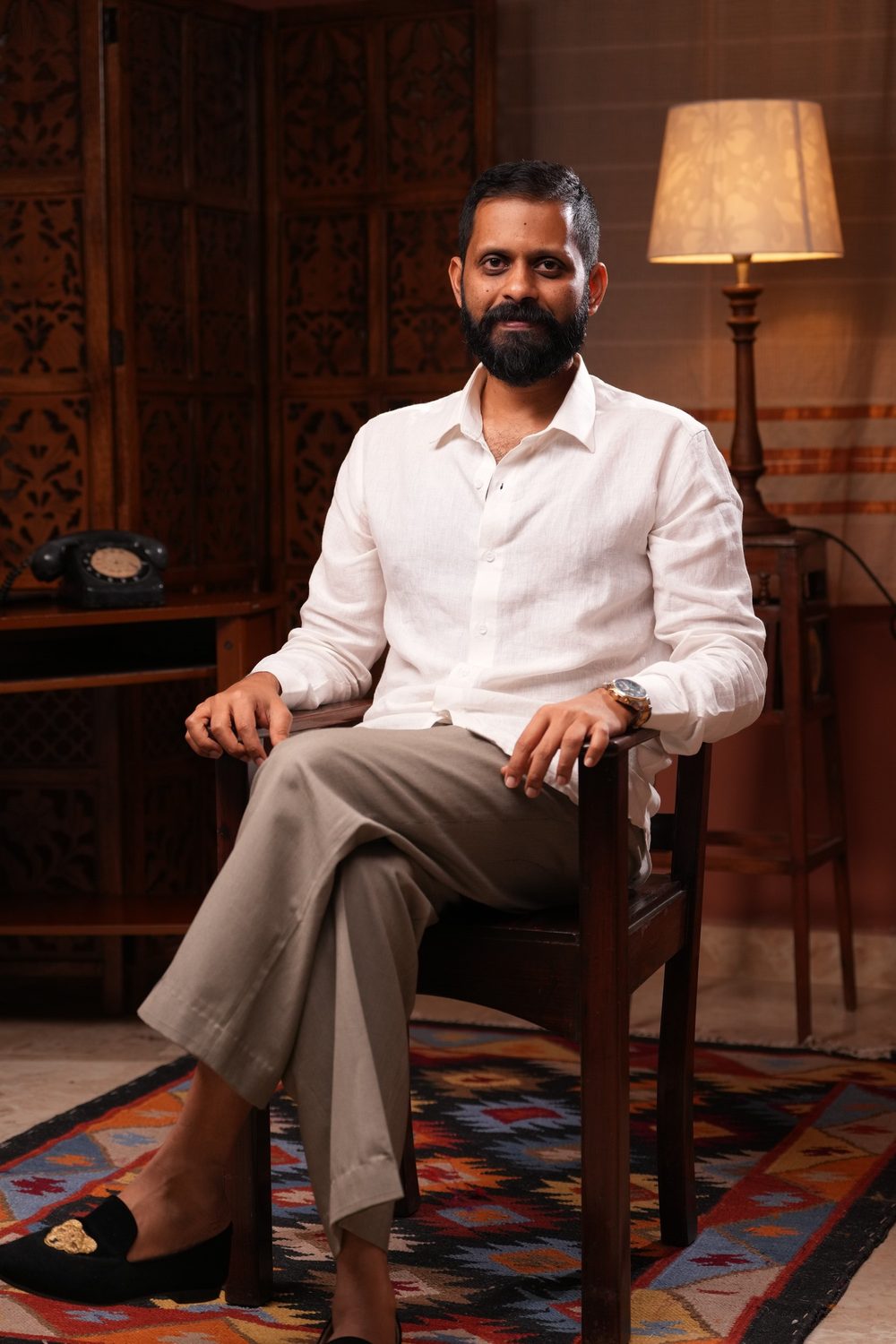 Shashank in a white linen shirt, seated, smiling at the camera.